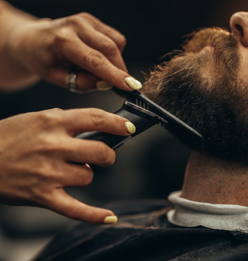 young-bearded-man-getting-beard-haircut-by-hairdresser-2.jpg